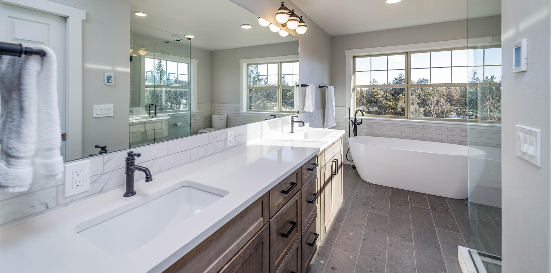 Bathroom with a freestanding tub, tiled floor, and double vanity